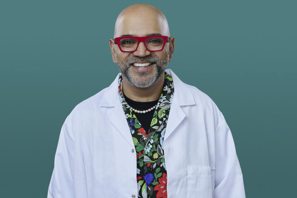 Dr Anand Patel in a white coat, red glasses and a floral shirt